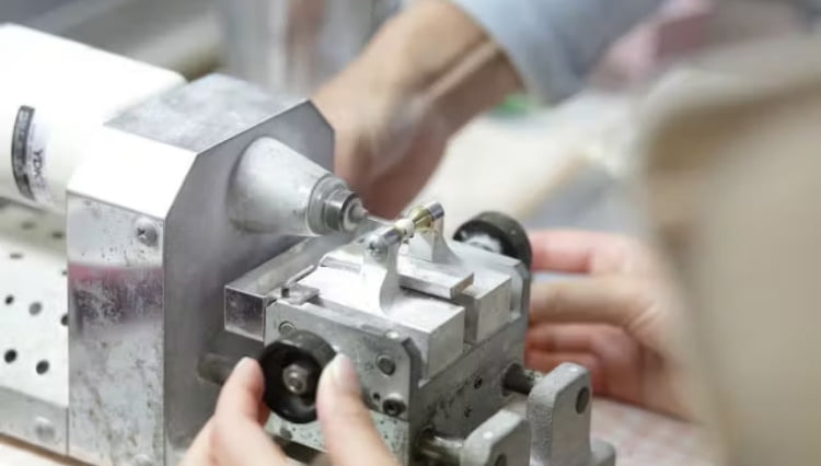 スタッフが真珠に孔をあけます